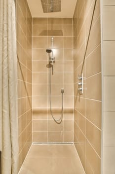 a walk in shower with beige tiled walls and white tiles on the wall behind it is an open shower stall