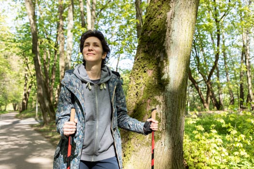 Portrait Woman Trekking With Sticks, Happy Caucasian 36 yo Hiking Female, Nordic Walking With Sticks, Cross-country Running. Horizontal Plane High quality photo