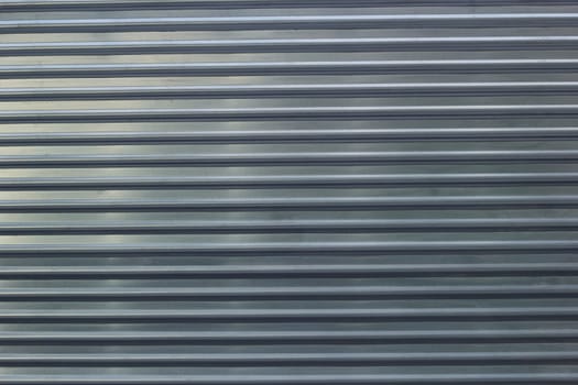 Photo of an abstract metal fence background. horizontal stripes. Roller shutters. Lift doors.