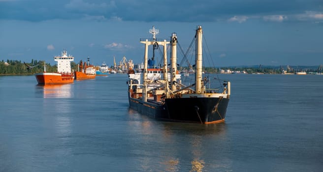 dry-cargo ships stand anchored in the roadstead awaiting loading.