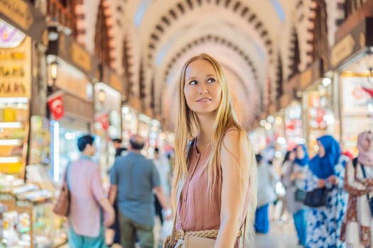 A tourist woman walks among the countless shops at the Grand Bazaar and Egyptian Bazaar in Istanbul. Shopping and travel in Turkey concept. Istanbul historical Egyptian Bazaar. Misir Carsisi, spice market. Turkiye.