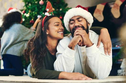 Couple hug, christmas and love at party, celebration and happiness on holiday in home living room. Man, woman and embrace to celebrate, romance and happy with smile, care and lounge in family home.