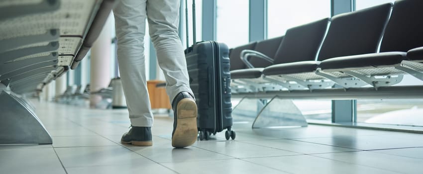 Airport, suitcase and person legs walking to flight for international opportunity or global journey in lobby. Luggage of entrepreneur or business man feet with vacation, travel agency or hospitality.