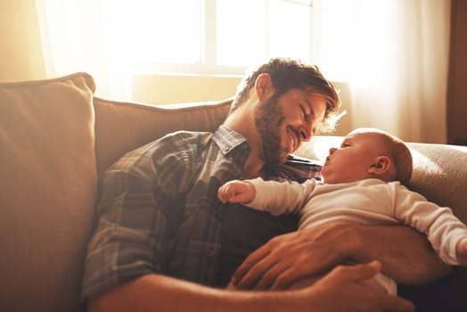 Father, baby and love on a family home sofa with love, care and support for a child. Happy man or dad with a smile and kid for bonding, development and growth or happiness in relationship with parent.
