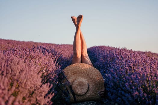 Selective focus. The girls legs stick out of the bushes, warm sunset light. Bushes of lavender purple in blossom, aromatic flowers at lavender fields.