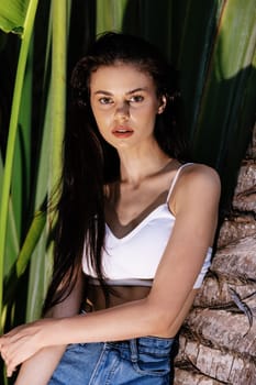 Beauty portrait of a young woman in front of palm trees, face and body skin care concept, the tropics, advertising beauty products. High quality photo