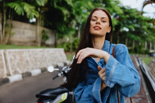 Portrait of a woman brunette smile with teeth walking outside against a backdrop of palm trees in the tropics, summer vacations and outdoor recreation, the carefree lifestyle of a freelance student. High quality photo