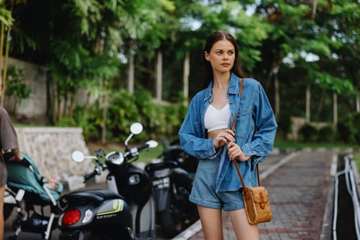 Portrait of a woman brunette smile with teeth walking outside against a backdrop of palm trees in the tropics, summer vacations and outdoor recreation, the carefree lifestyle of a freelance student. High quality photo