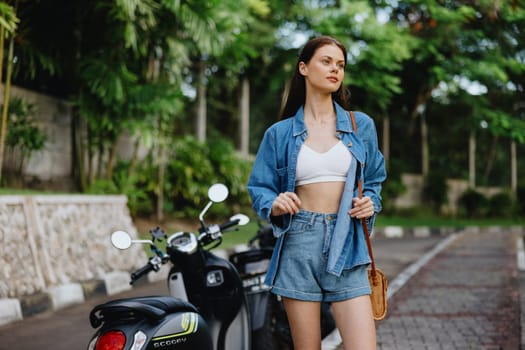 Portrait of a woman brunette smile with teeth walking outside against a backdrop of palm trees in the tropics, summer vacations and outdoor recreation, the carefree lifestyle of a freelance student. High quality photo