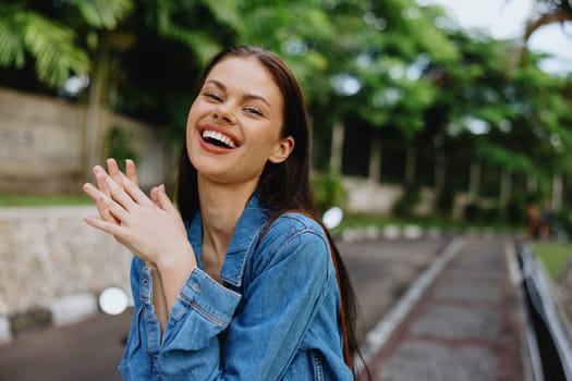 Portrait of a woman brunette smile with teeth walking outside against a backdrop of palm trees in the tropics, summer vacations and outdoor recreation, the carefree lifestyle of a freelance student. High quality photo