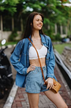 Portrait of a woman brunette smile with teeth walking outside against a backdrop of palm trees in the tropics, summer vacations and outdoor recreation, the carefree lifestyle of a freelance student. High quality photo