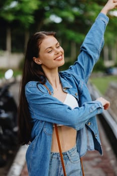 Portrait of a woman brunette smile with teeth walking outside against a backdrop of palm trees in the tropics, summer vacations and outdoor recreation, the carefree lifestyle of a freelance student. High quality photo