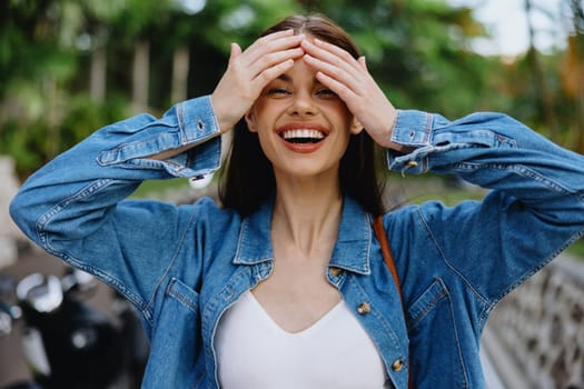 Portrait of a woman brunette smile with teeth walking outside against a backdrop of palm trees in the tropics, summer vacations and outdoor recreation, the carefree lifestyle of a freelance student. High quality photo