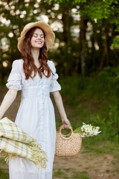 portrait of a happy woman in a light dress and a wicker hat with a plaid in her hands. High quality photo