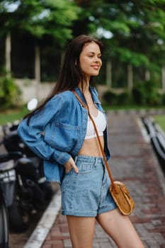 Portrait of a woman brunette smile with teeth walking outside against a backdrop of palm trees in the tropics, summer vacations and outdoor recreation, the carefree lifestyle of a freelance student. High quality photo