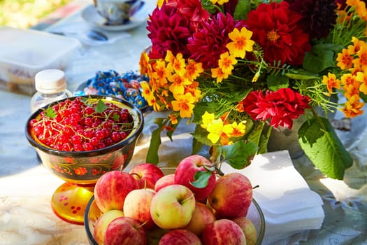 Set table in summer with apples, red currants, flowers. The concept of proper nutrition in summer