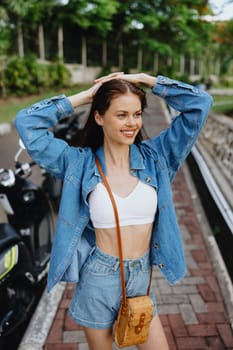 Portrait of a woman brunette smile with teeth walking outside against a backdrop of palm trees in the tropics, summer vacations and outdoor recreation, the carefree lifestyle of a freelance student. High quality photo