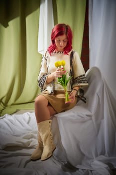 Beautiful woman with red hair on light background holds tulips. Inernational woman's day 8 March