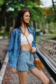 Portrait of a woman brunette smile with teeth walking outside against a backdrop of palm trees in the tropics, summer vacations and outdoor recreation, the carefree lifestyle of a freelance student. High quality photo