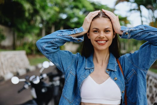 Portrait of a woman brunette smile with teeth walking outside against a backdrop of palm trees in the tropics, summer vacations and outdoor recreation, the carefree lifestyle of a freelance student. High quality photo