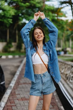 Portrait of a woman brunette smile with teeth walking outside against a backdrop of palm trees in the tropics, summer vacations and outdoor recreation, the carefree lifestyle of a freelance student. High quality photo