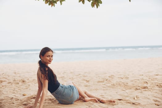 woman tropical caucasian young happy sand nature back freedom person view adult holiday sun beach vacation coast sitting travel attractive sea smile