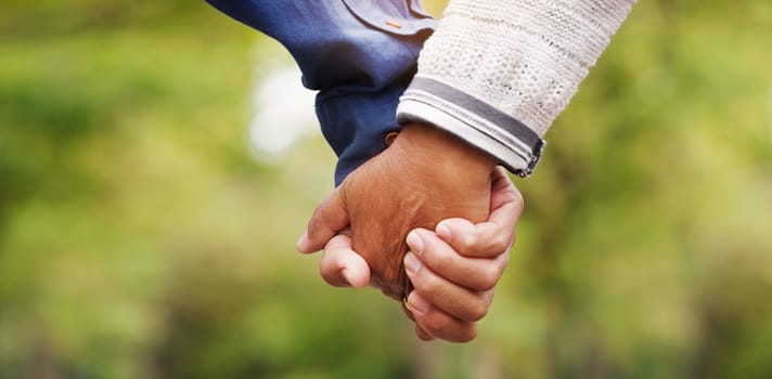 Closeup, love and couple holding hands, outdoor and relationship with romance, bonding and support. Zoom, partners and man with woman, touching hand and trust with solidarity, marriage and nature.