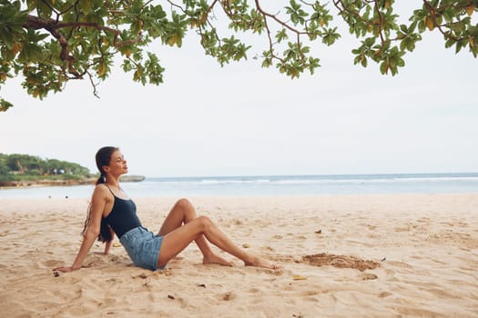 woman carefree holiday water long freedom beach sitting travel alone hair fashion person beauty sand sea smile relax young vacation girl nature