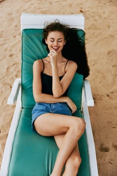 resting woman beach sitting sea tan hat person bikini lying holiday resort sunbed exotic sun ocean brunette smiling lifestyle vacation sand