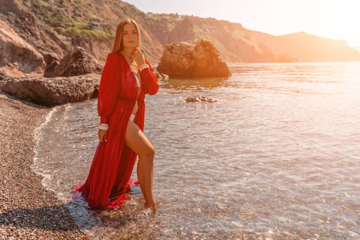 woman sea red dress Happy woman in a flying red dress and with long hair, stands on the seashore.