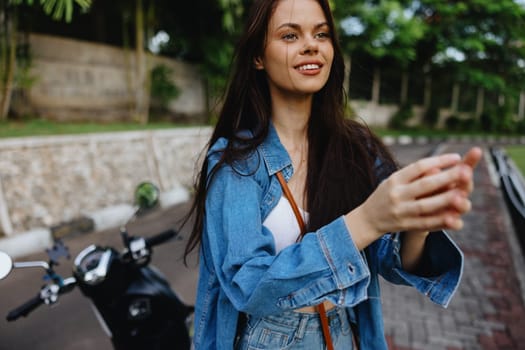 Portrait of a woman brunette smile with teeth walking outside against a backdrop of palm trees in the tropics, summer vacations and outdoor recreation, the carefree lifestyle of a freelance student. High quality photo