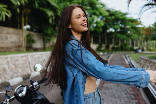 Portrait of a woman brunette smile with teeth walking outside against a backdrop of palm trees in the tropics, summer vacations and outdoor recreation, the carefree lifestyle of a freelance student. High quality photo