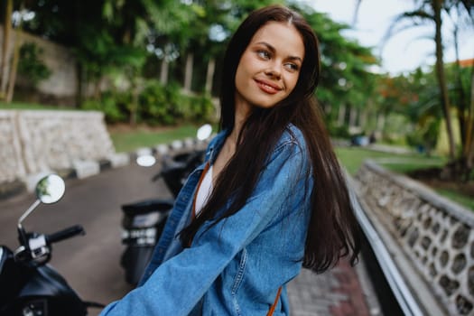 Portrait of a woman brunette smile with teeth walking outside against a backdrop of palm trees in the tropics, summer vacations and outdoor recreation, the carefree lifestyle of a freelance student. High quality photo