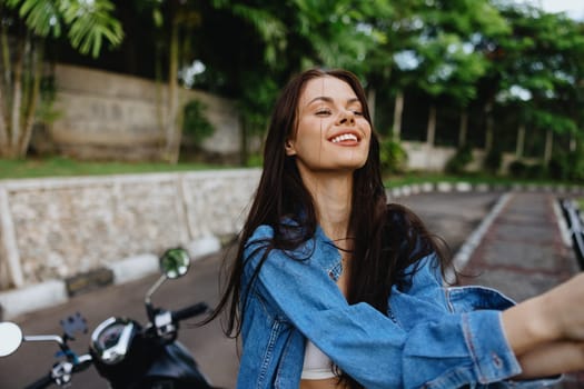 Portrait of a woman brunette smile with teeth walking outside against a backdrop of palm trees in the tropics, summer vacations and outdoor recreation, the carefree lifestyle of a freelance student. High quality photo