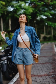 Portrait of a woman brunette smile with teeth running down the street against a backdrop of palm trees in the tropics, summer vacations and outdoor recreation, the carefree lifestyle of a freelance student. High quality photo