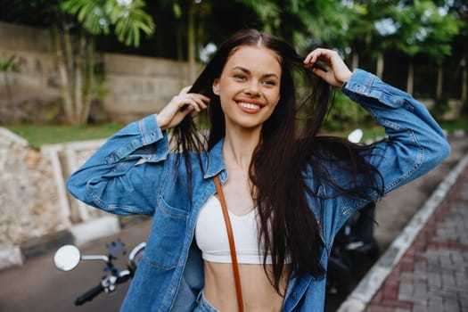 Portrait of a woman brunette smile with teeth walking outside against a backdrop of palm trees in the tropics, summer vacations and outdoor recreation, the carefree lifestyle of a freelance student. High quality photo