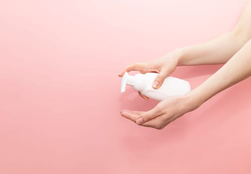 Female Hands Presses Dispenser OF Blank White Bottle, Plastic Tube On Pink Background. Hygiene, Cosmetic Beauty Product, Washing, Cleansing Intimate Gel, Foam. Daily Body Care. Horizontal, Copyspace.