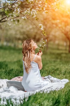 Portrait of a blonde in the park. Happy woman with long blond hair in a blue dress