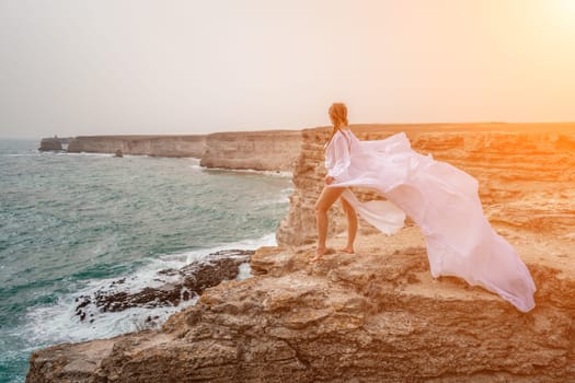 Woman sea white dress. Happy freedom woman on the beach enjoying and posing in white dress. Rear view of a girl in a fluttering white dress in the wind. Holidays, holidays at sea