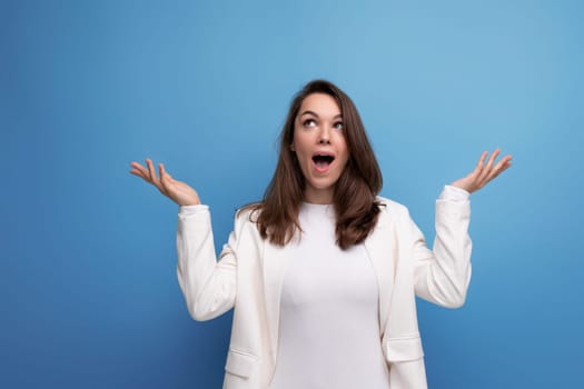 lucky happy brunette woman in dress on studio background with copyspace.