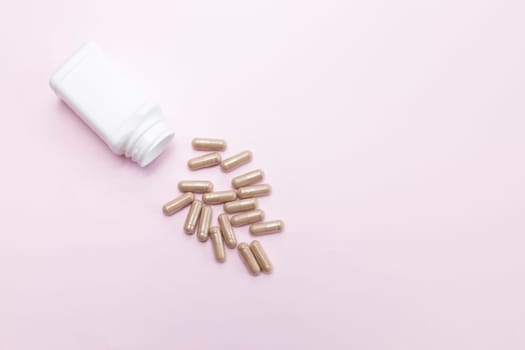 Scattered Tablets, Capsules OF Slippery Elm, White Bottle, Container On Pink Background. Dietary Nutritional Supplement, Medication. Ulmus Fulva, Herbal Remedy Concept. Horizontal,Copy space For Text