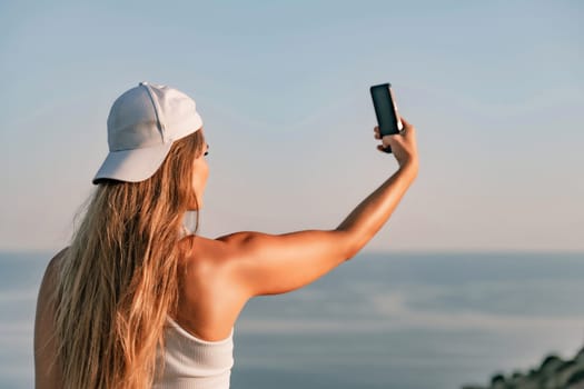 Selfie woman in cap and tank top making selfie shot mobile phone post photo social network outdoors on sea background beach people vacation lifestyle travel concept