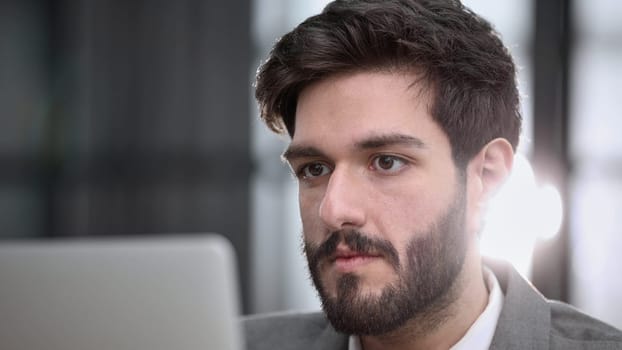 focused young businessman looking at computer monitor