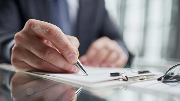 man hands with pen writing on notebook in the office.learning, education and work