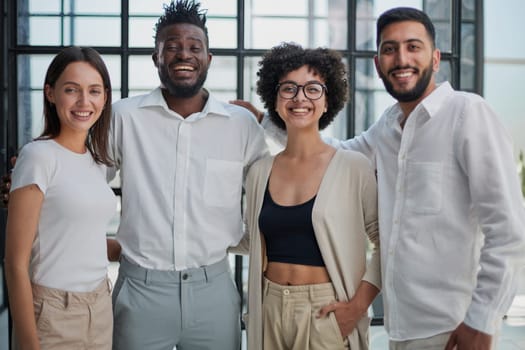 Portrait of successful creative business team looking at camera and smiling. Diverse business people standing together at startup.