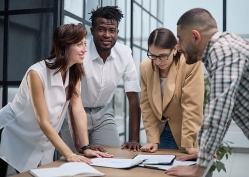 Business team discussing financial charts while standing at the table in the office
