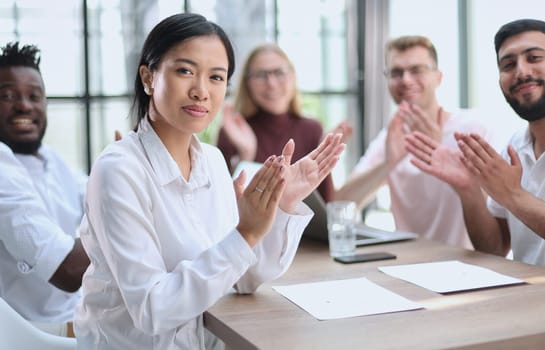 Group of happy business colleagues at a meeting in the office applauding