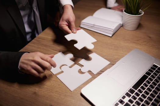 Crop close up of businessman hold pieces of jigsaw puzzle think of business problem solution or idea.