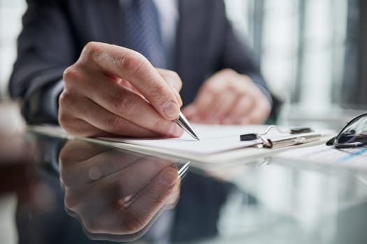 man hands with pen writing on notebook in the office.learning, education and work