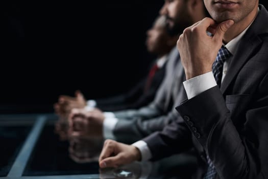 Close-up profile of a pensive manager, holding his hand on his chin